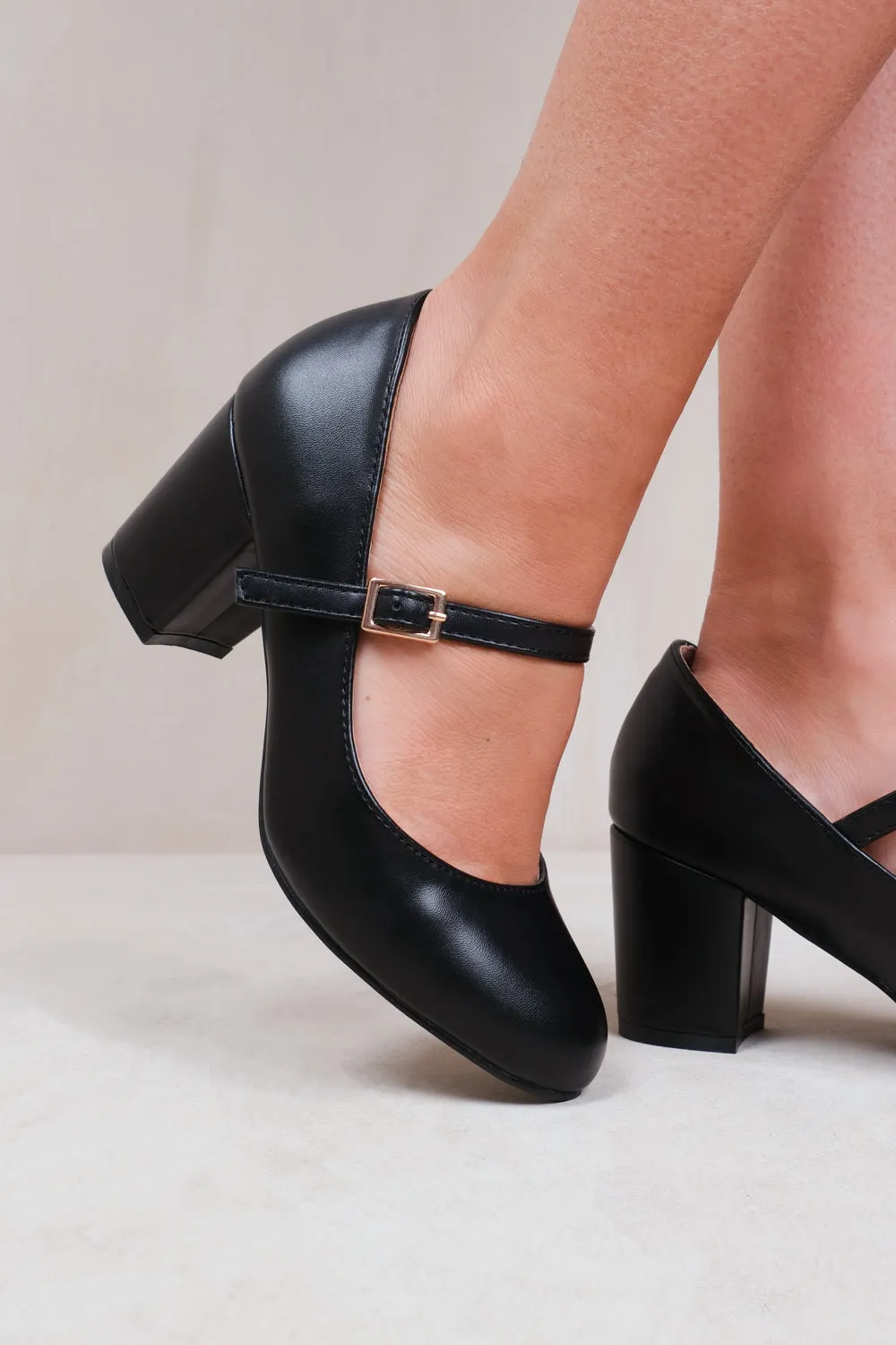 ARACELI BLOCK HEEL MARY JANE PUMPS IN BLACK FAUX LEATHER